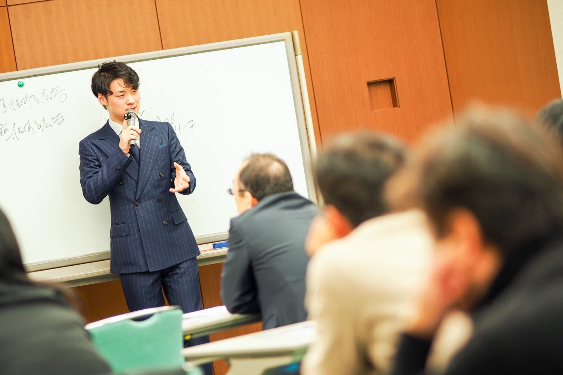 ホワイトボードの前で講義する坂本翔